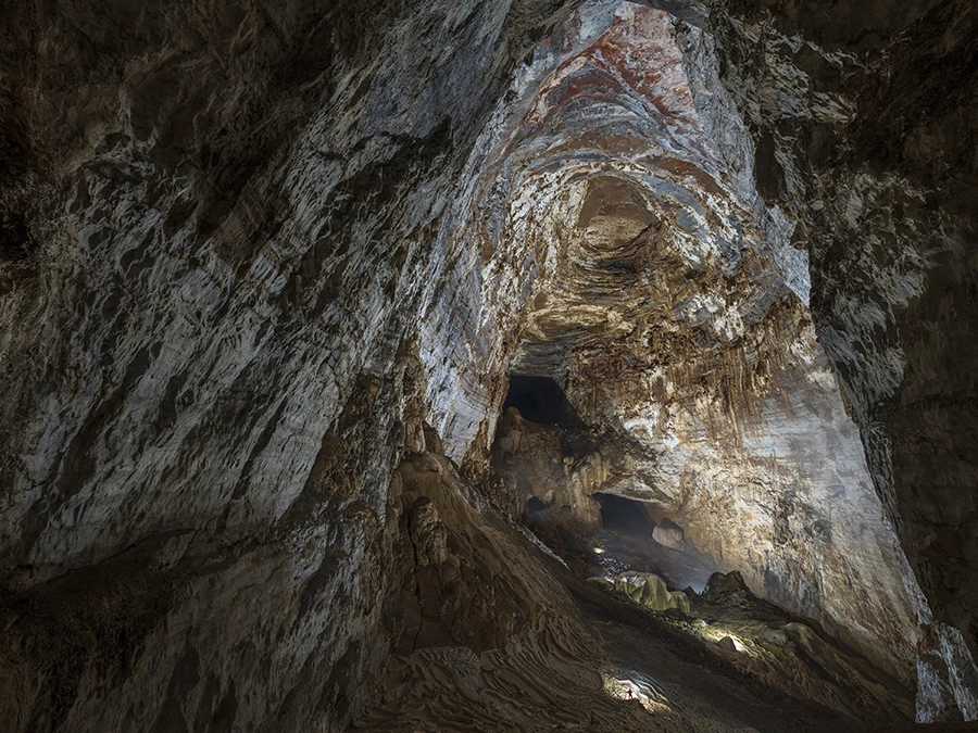 《恢弘的地下空间》高大险峻的广西乐业县红玫瑰地下洞穴大厅，其最大高度220米，探险队员在大厅里显得很渺小，洞壁上岩层的纹理线条与大厅拱顶的漩涡形态在视觉上令人仿佛感觉到远古的洪荒之力造就的自然奇观。（富士GFX100s GF23mm 镜头) 李晋摄影.jpg